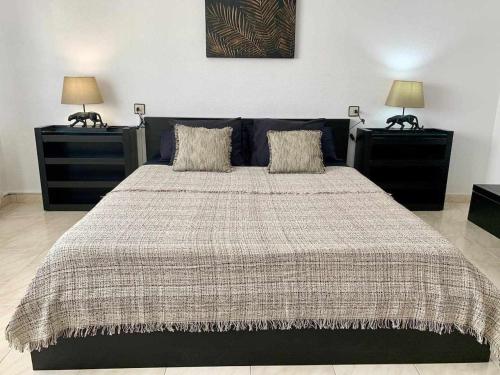 a bedroom with a large bed with two night stands at Lilo 30, Only Families, Puy du Fou in Olías del Rey