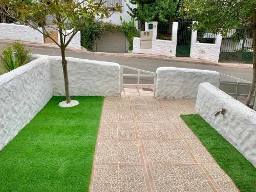 a park with concrete walls and a tree and grass at Lilo 30, Only Families, Puy du Fou in Olías del Rey