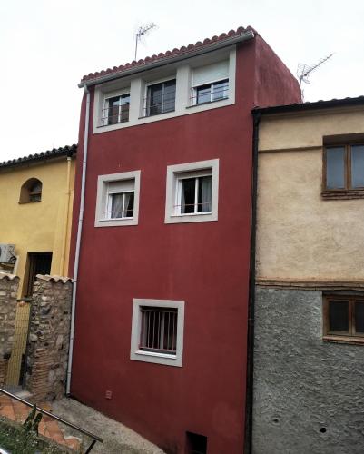 a red building with white windows on a street at CALANURI in García