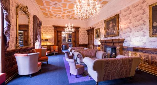 a living room filled with furniture and a fire place at Ardoe House Hotel & Spa in Aberdeen