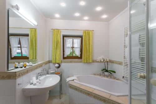a white bathroom with a tub and a sink at Landhaus Stephanie in Krün
