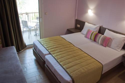 a hotel room with a large bed with a balcony at Hotel Olympos in Leptokaria