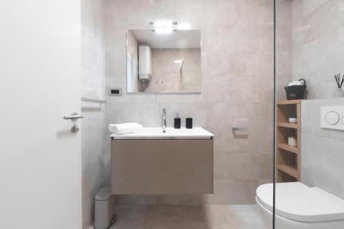 a white bathroom with a sink and a toilet at WISH Apartments in Korčula