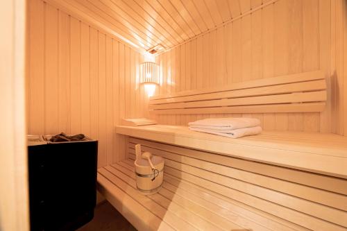 a sauna with towels on a shelf and a lamp at SlowDown Travemünde in Travemünde