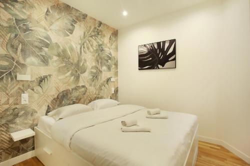 - une chambre avec un lit blanc et un papier peint tropical dans l'établissement Rent a Room - Tracy apartment, à Paris