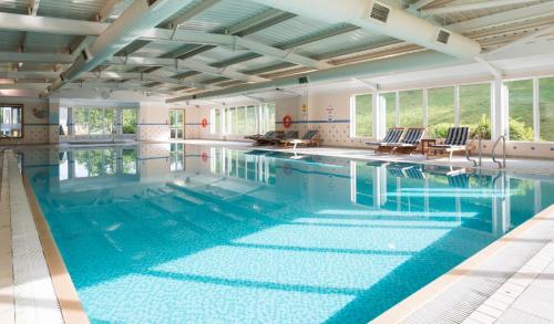 a large swimming pool with blue water at Ardoe House Hotel & Spa in Aberdeen