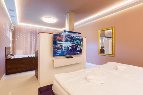 a bedroom with a bed and a tv on the wall at Lilly De Luxe Apartment with jacuzzi in Michałowice