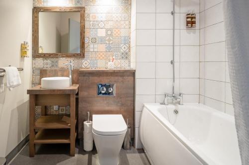 a bathroom with a tub and a toilet and a sink at Abel Heywood Boutique Hotel in Manchester