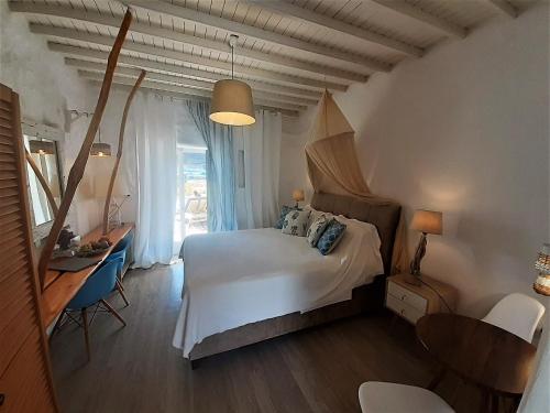 a bedroom with a white bed and a window at Sea Side Studios & Houses in Kalo Livadi