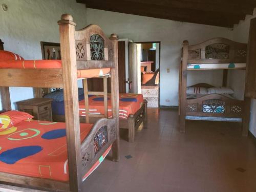 a room with two bunk beds and a room with another bed at Finca Sanfelipe in Calima