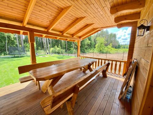 drewniana ławka na ganku kabiny w obiekcie Całoroczne domy z bala - CASA DEL CZYŻYK w mieście Serwy