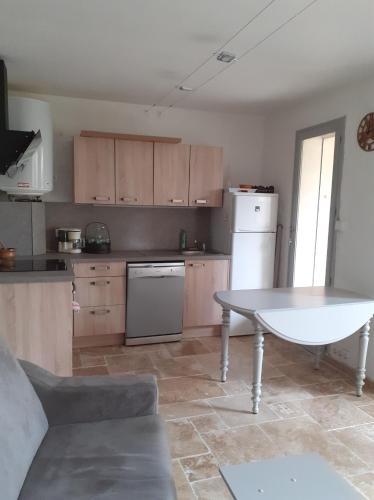 Il comprend une cuisine équipée d'une table blanche et d'un réfrigérateur blanc. dans l'établissement RESIDENCE PORTO DI MAR CAVALAIRE, à Cavalaire-sur-Mer