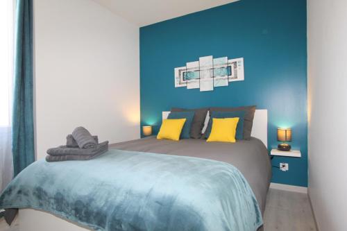 1 dormitorio con 1 cama con paredes azules y almohadas amarillas en Le First by EasyEscale, en Romilly-sur-Seine