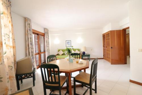 a dining room and living room with a table and chairs at Bellavista Avenida By BeGuest in Albufeira