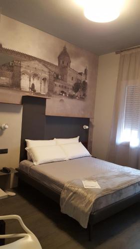 a bedroom with a bed with a picture of a building at Alma Hotel in Palermo