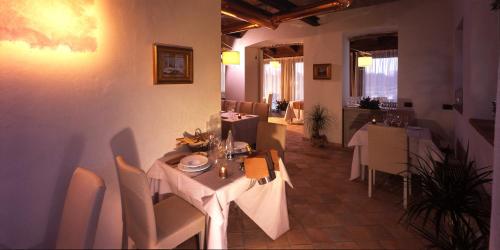 a restaurant with white tables and chairs in a room at Relais Bella Rosina Pool & Spa in Fiano
