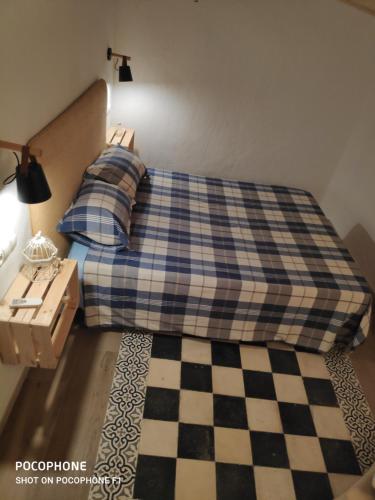 a bedroom with a bed with a checkered floor at Refugio de El Chorro in El Chorro