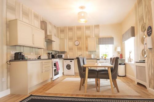 a kitchen with a table and chairs in a room at The Lodge House Callander in Callander