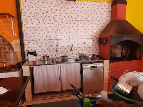 a kitchen with a sink and a pizza oven at Suítes Recanto Renascer in Caraguatatuba