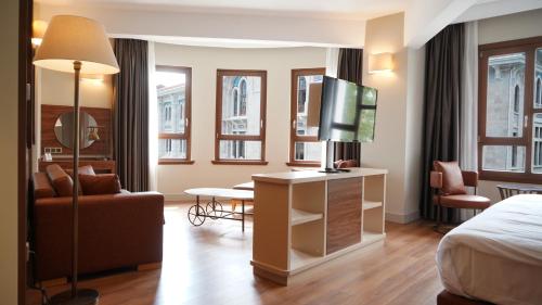 a hotel room with a bed and a living room at Grand Sirkeci Hotel in Istanbul
