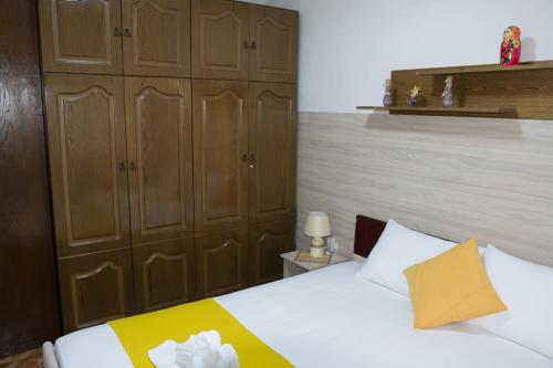 a bedroom with a bed and wooden cabinets at Apartment Elmari in Prilep