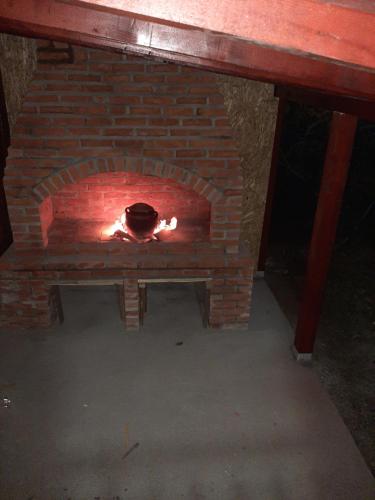 a brick oven with a fire in it at Kuca sa bazenom Teja in Arandjelovac