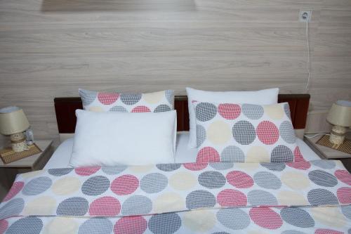 a bed with polka dot sheets and pillows at Apartment Elmari in Prilep
