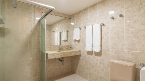 a bathroom with a shower and a sink and a toilet at Aram Beach & Convention in João Pessoa