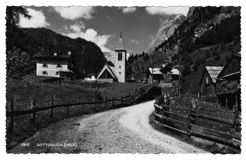 a black and white photo of a village with a church at Alpenhotel La Montanara in Rocca Pietore