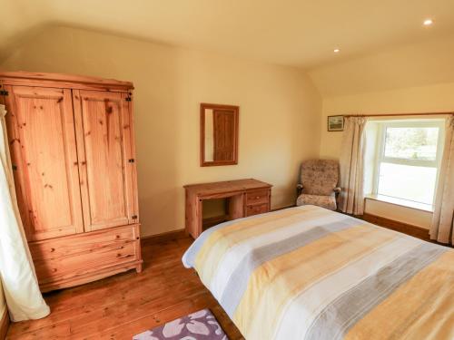 1 dormitorio con 1 cama, vestidor y ventana en Penllyn, en Llanfairpwllgwyngyll