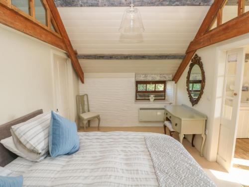 a bedroom with a bed and a desk and a window at The Coach House in Pembroke
