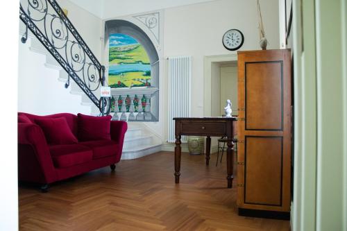 sala de estar con sofá rojo y mesa en Residenza delle Grazie, en Miglionico