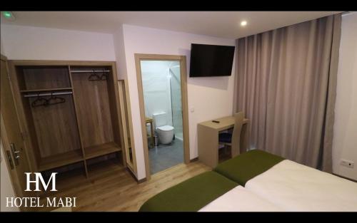 a hotel room with a bed and a mirror at Hotel MABI in Valença