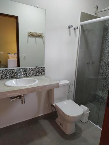 um banheiro com vaso sanitário, pia e chuveiro em Estalagem Itamambuca em Ubatuba