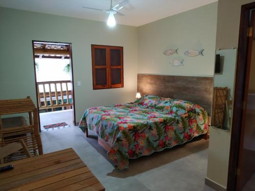 um quarto com uma cama com uma colcha colorida em Estalagem Itamambuca em Ubatuba