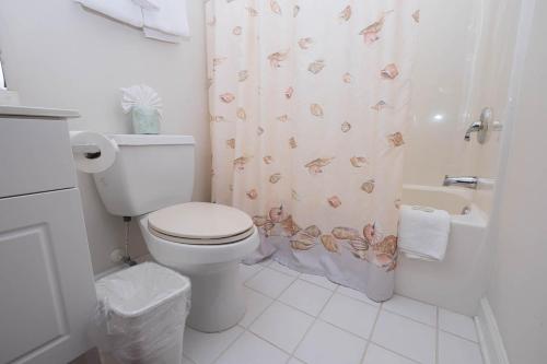 a bathroom with a toilet and a shower curtain with butterflies at Barefoot Resort Golf & Yacht Club Villas in Myrtle Beach