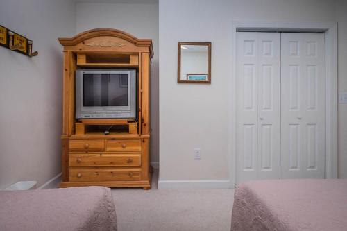 telewizor na drewnianej komodzie w sypialni w obiekcie Barefoot Resort Golf & Yacht Club Villas w mieście Myrtle Beach
