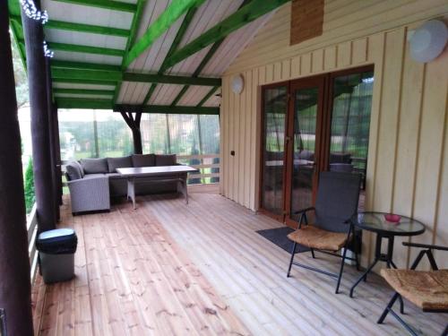 a screened porch with a couch and a table and chairs at Mustvee Creek Cottage in Mustvee