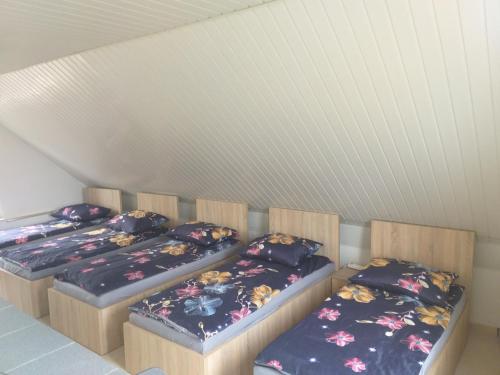 drie aparte bedden in een kamer met een plafond bij Domek K2 - Niezależny 5 osobowy - NoclegiGrodziskPL 792-535-535 in Grodzisk Mazowiecki