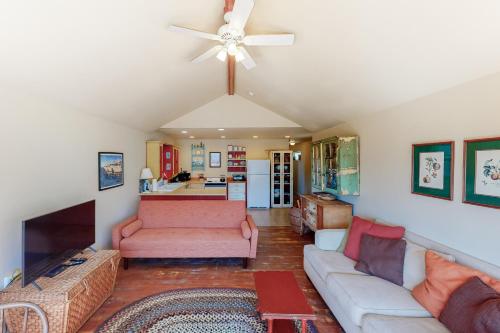 a living room with a couch and a ceiling fan at Beach Cabin Getaway in Rockaway Beach