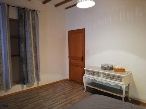 een kamer met een bed, een tafel en een deur bij F2 Saint Lambert Verdun in Verdun-sur-Meuse