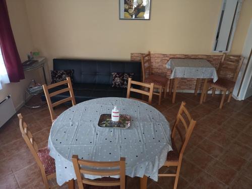 a dining room with a table and chairs with a cake on it at Tündér Szálló Eplény in Eplény