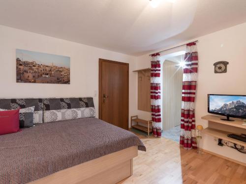 a bedroom with a bed and a flat screen tv at Haus Laimbauer in Kirchdorf in Tirol