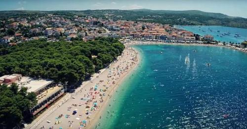 an aerial view of a beach with people in the water at Apartmani Slavka in Primošten