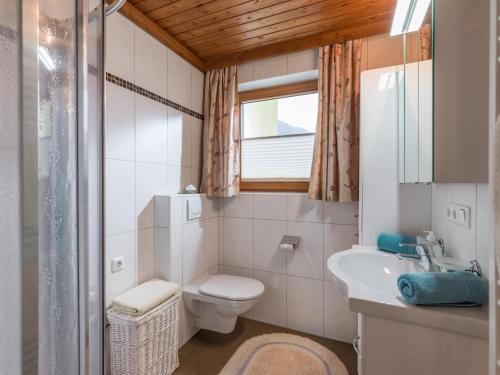 a bathroom with a toilet and a sink and a window at Haus Laimbauer in Kirchdorf in Tirol