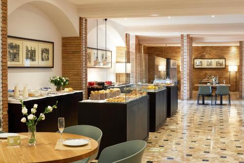un restaurant avec un buffet composé de tables et de chaises dans l'établissement Hotel Fernando III, à Séville
