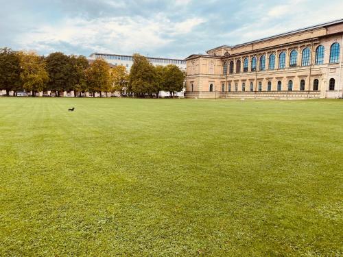 a large grass field in front of a building at Exclusive Maxvorstadt Studio in Munich