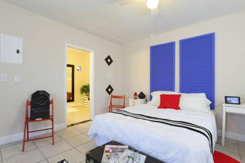 a bedroom with a bed with blue shutters and a fireplace at Chic and Comfortable Studio Free Street Parking in Miami