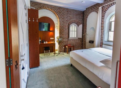 a bedroom with a bed and a brick wall at Leerhotel Het Klooster in Amersfoort
