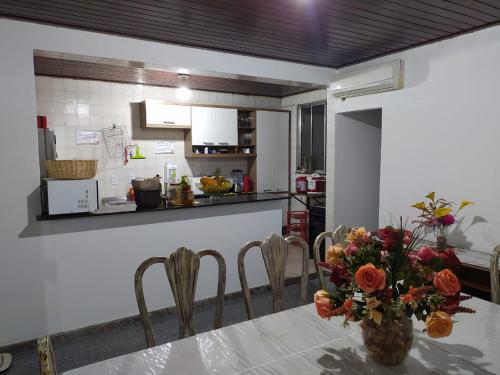 una cocina con una mesa con un jarrón de flores. en Hostel My Place Hospedaria, en Salvador